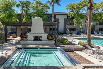 poolside covered lounging area with a fireplace at Avora apartments